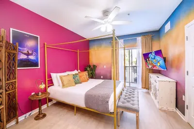 a bedroom with a bed and a pink wall at Upstay - Disney Themed Apartment w Luxury Patio in Orlando