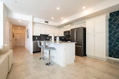 a kitchen with white cabinets and a black refrigerator at 3191 Unit 207 Stunning apartment in Kissimmee