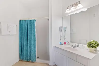 a bathroom with a blue shower curtain and a sink at 4814 Cayview Avenue 406 in Orlando