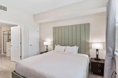 a bedroom with a large white bed and two lamps at 4012 Breakview Drive 110 in Orlando