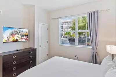 a bedroom with a bed and a tv and a window at 4012 Breakview Drive 110 in Orlando