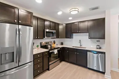 a kitchen with wooden cabinets and stainless steel appliances at 4012 Breakview Drive 210 in Orlando
