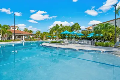 a swimming pool at a resort with blue umbrellas at 4012 Breakview Drive 210 in Orlando