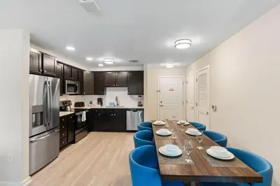 a kitchen and dining room with a wooden table and blue chairs at 4013 Breakview Drive 108 in Orlando