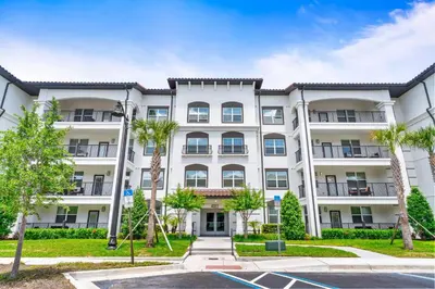 a large white apartment building with palm trees at 4013 Breakview Drive 108 in Orlando
