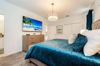 a bedroom with a large bed and a dresser at New Beautiful 7 br w pool games theme rooms in Kissimmee