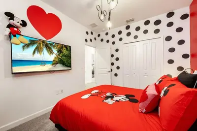 a bedroom with a red bed with mickey mouse on it at New Beautiful 7 br w pool games theme rooms in Kissimmee