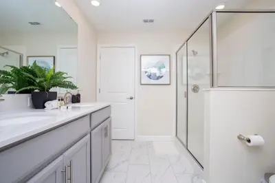 a white bathroom with a shower and a sink at 4577 Stunning 7 bedroom home in Kissimmee