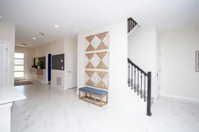 a living room with a stair case and a chair at 4577 Stunning 7 bedroom home in Kissimmee