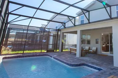 a house with a swimming pool with a glass roof at 4577 Stunning 7 bedroom home in Kissimmee