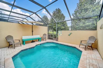 a swimming pool with a table and chairs and a tableasteryasteryasteryasteryastery at Townhome near Disney with pool Magic and Fun at Windsor in Orlando