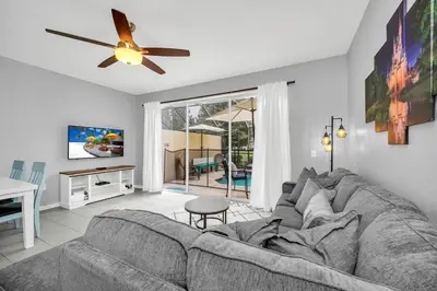 a living room with a couch and a ceiling fan at Townhome near Disney with pool Magic and Fun at Windsor in Orlando