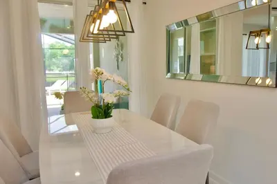 a dining room with a table with chairs and a mirror at Cozy & Magical place sleeps 12/10 min from Disney in Kissimmee