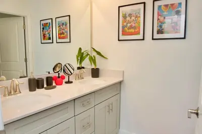a bathroom with a sink and a mirror at Cozy & Magical place sleeps 12/10 min from Disney in Kissimmee