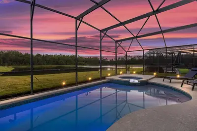a swimming pool in a building with a sunset at Lake View Vacation Home with Pool and Game Room Near Disney Parks in Kissimmee