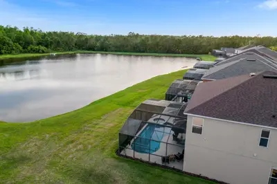 an aerial view of a house with a pond at Lake View Vacation Home with Pool and Game Room Near Disney Parks in Kissimmee