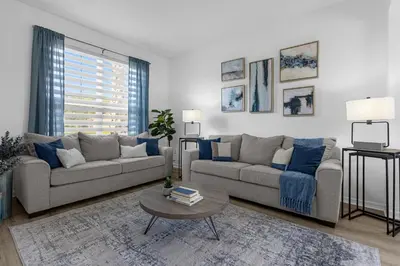 a living room with two couches and a table at Lake View Vacation Home with Pool and Game Room Near Disney Parks in Kissimmee