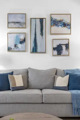 a living room with a couch and paintings on the wall at Lake View Vacation Home with Pool and Game Room Near Disney Parks in Kissimmee