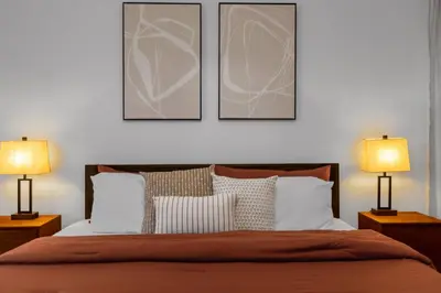 a bedroom with a bed with two lamps and three pictures at Lake View Vacation Home with Pool and Game Room Near Disney Parks in Kissimmee