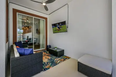 a living room with a couch and a tv on the wall at Relax in Style at this Spacious 4-Bedroom Villa in Kissimmee