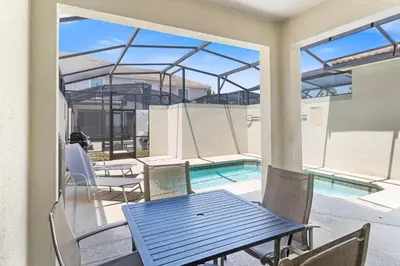 a patio with a table and chairs and a swimming pool at 4813 Crusoe Street in Kissimmee