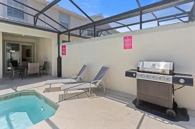 a patio with a grill and a swimming pool at 4813 Crusoe Street in Kissimmee