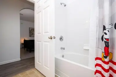a white bathroom with a tub and a shower stall at Dream Cozy 3BR Condo - Disney 5 Min Walk to Pool in Orlando