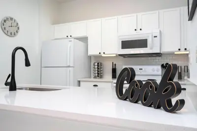a kitchen with white cabinets and a sign that says ciao at Dream Cozy 3BR Condo - Disney 5 Min Walk to Pool in Orlando