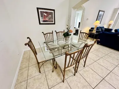 a dining room with a glass table and chairs at Spacious, Open Layout And Pool Relaxation! in Orlando