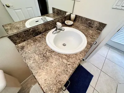 a bathroom counter with a sink and a mirror at Spacious, Open Layout And Pool Relaxation! in Orlando
