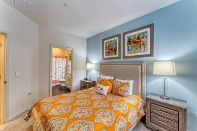 a bedroom with a bed and a blue wall at Happy Holiday Hideaway G in Kissimmee