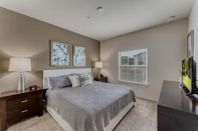 a bedroom with a bed and a dresser and a window at Happy Holiday Hideaway G in Kissimmee