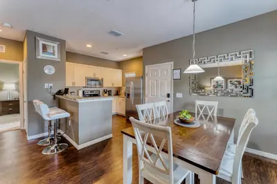 a kitchen and dining room with a table and chairs at Happy Holiday Hideaway G in Kissimmee