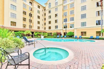 a hot tub in a courtyard with chairs and a building at Family Friendly 1BR Suite with Swimming Pool - Near Disney in Orlando