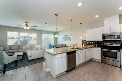 a kitchen with white cabinets and a living room at Making Memories G in Kissimmee