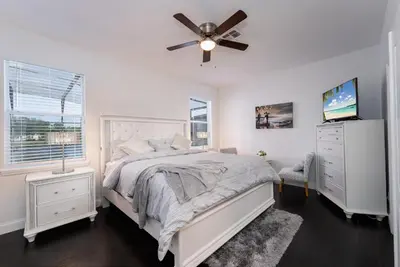 a white bedroom with a bed and a ceiling fan at Lakeview Villa G in Orlando
