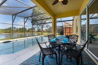 a patio with a table and chairs and a pool at Lakeview Villa G in Orlando