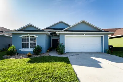 a blue house with a white garage at Eagle's End S in Kissimmee