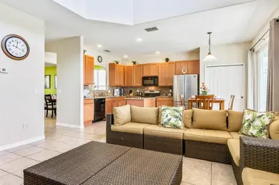 a living room with a couch and a kitchen at 6 bedrooms pool home Gated resort Veranda Palms in Kissimmee