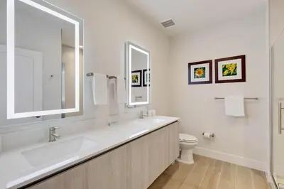 a white bathroom with a sink and a toilet at 4 bedrooms pool home Hidden Forest Resort Amenities in Orlando