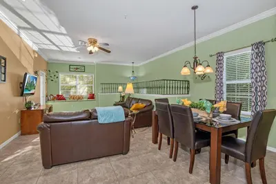 a dining room and living room with a table and chairs at 3 bedrooms townhome Gated Resort 5 minutes from Disney in Orlando