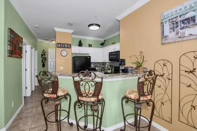 a kitchen with two bar stools in a room at 3 bedrooms townhome Gated Resort 5 minutes from Disney in Orlando