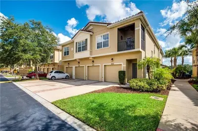 a house with a car parked in front of it at 3 bedrooms townhome Gated Resort 5 minutes from Disney in Orlando