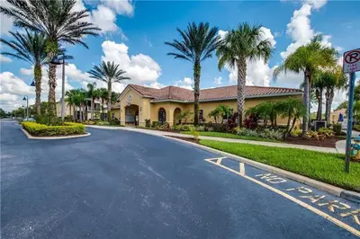 a house on a street with palm trees at 3 bedrooms townhome Gated Resort 5 minutes from Disney in Orlando