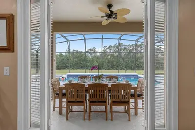 a dining room with a table and a pool at Lakeview w/8 Bedroom 5 KingSuite 3 miles to Disney in Kissimmee