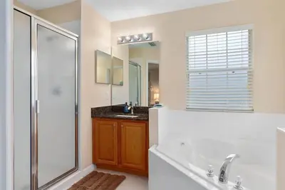 a bathroom with a tub and a shower and a sink at Lakeview w/8 Bedroom 5 KingSuite 3 miles to Disney in Kissimmee