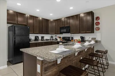 a kitchen with a black refrigerator and a counter top at 4732TH Cozy home in Kissimmee in Kissimmee