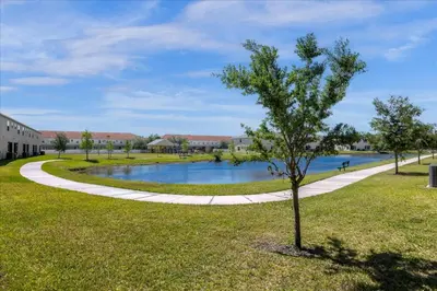 a tree in the middle of a park with a pond at 4732TH Cozy home in Kissimmee in Kissimmee