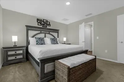 a bedroom with a large bed and a nightstand and a bed sidx sidx sidx at 4732TH Cozy home in Kissimmee in Kissimmee