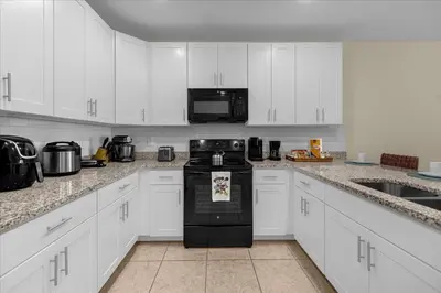 a kitchen with white cabinets and a black appliance at 3BD townhome near Disney 4730 in Kissimmee